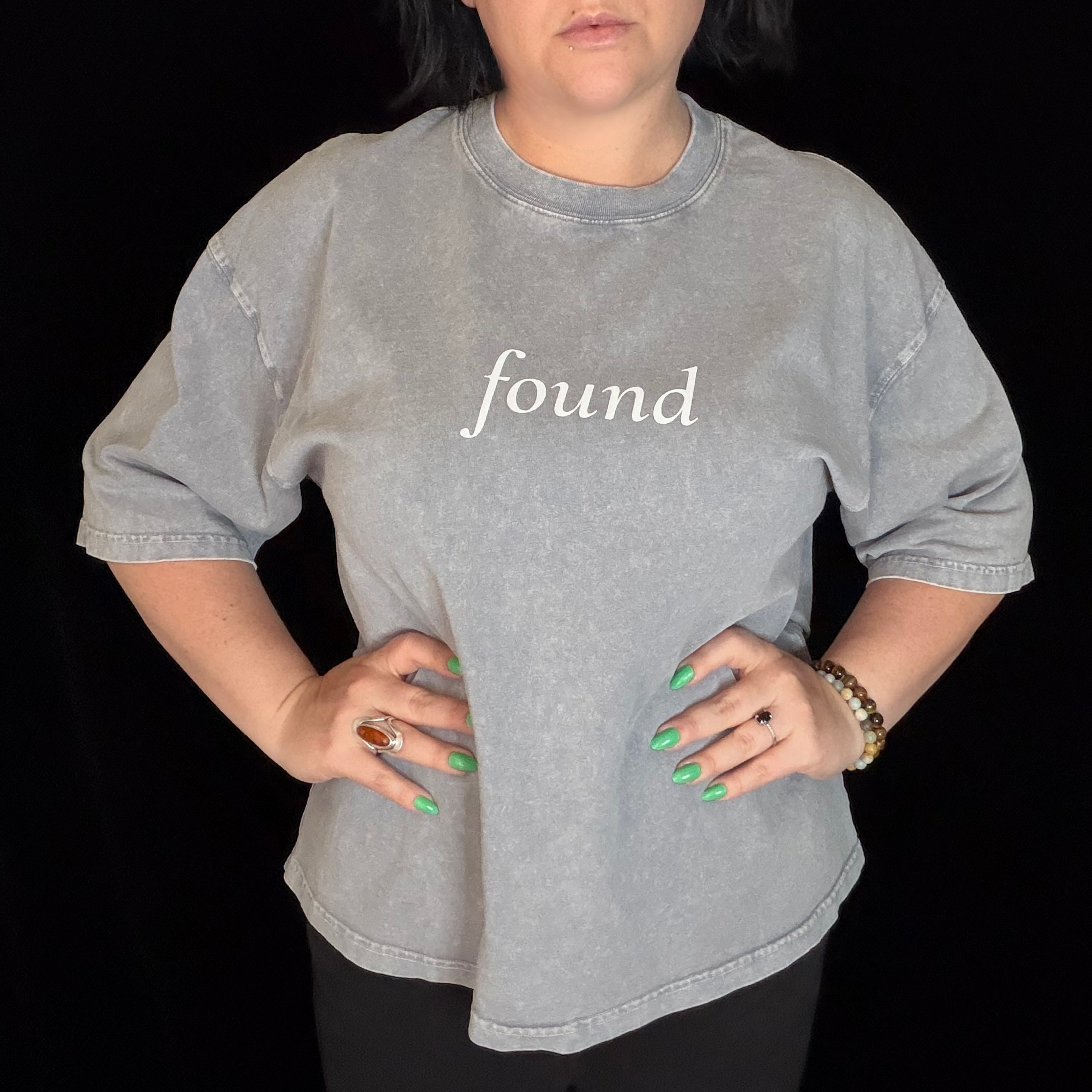 alt millennial woman wearing light gray boxy tee with text found on the center chest