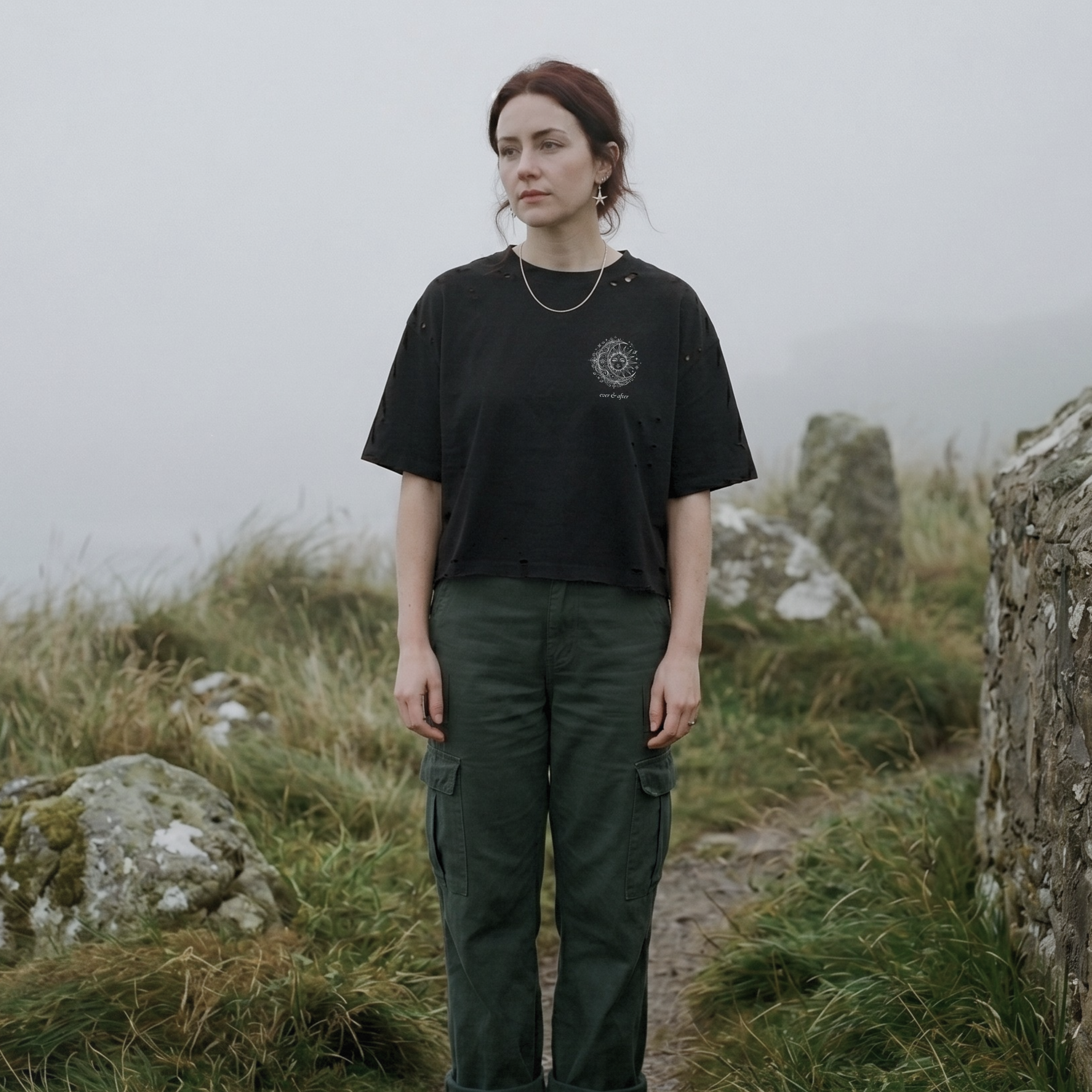 alt millennial woman wearing distressed black boxy tee with sun and moon design small on left chest with small brand word mark: ever & after