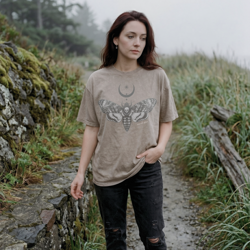 alt millennial woman wearing snow wash light beige oversized tee with moth and moon design center on chest and brand word mark underneath