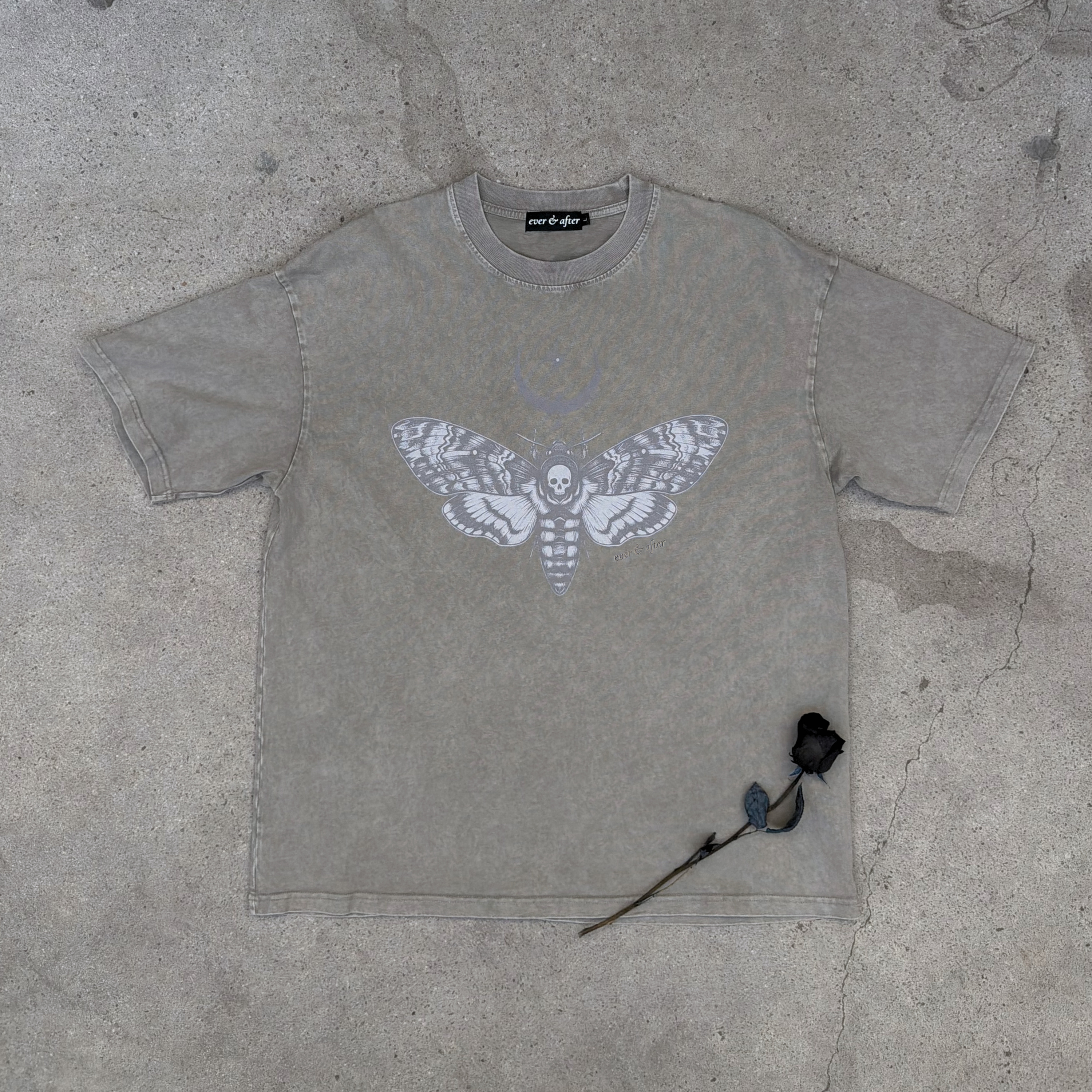 bone wash oversized moth tee lay flat on concrete with rose