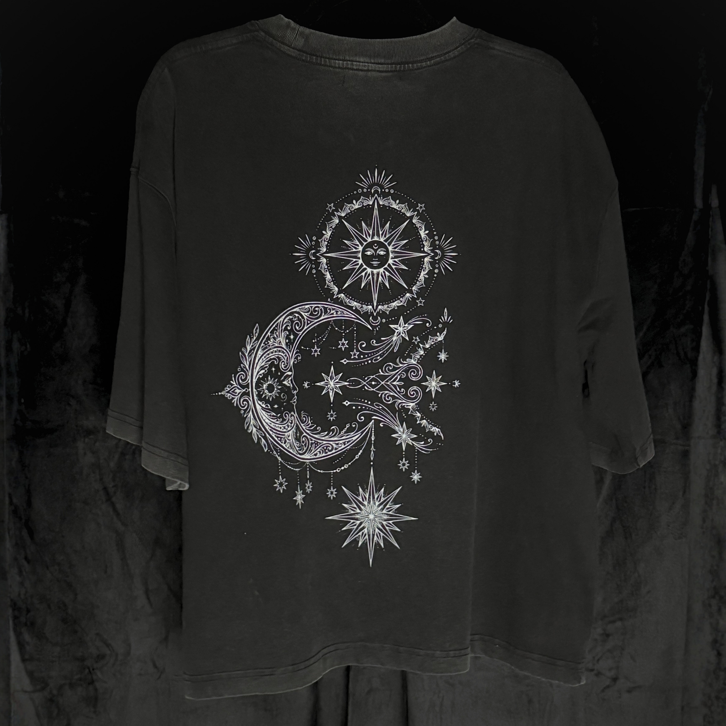Black long-sleeve shirt with celestial design on a dark background