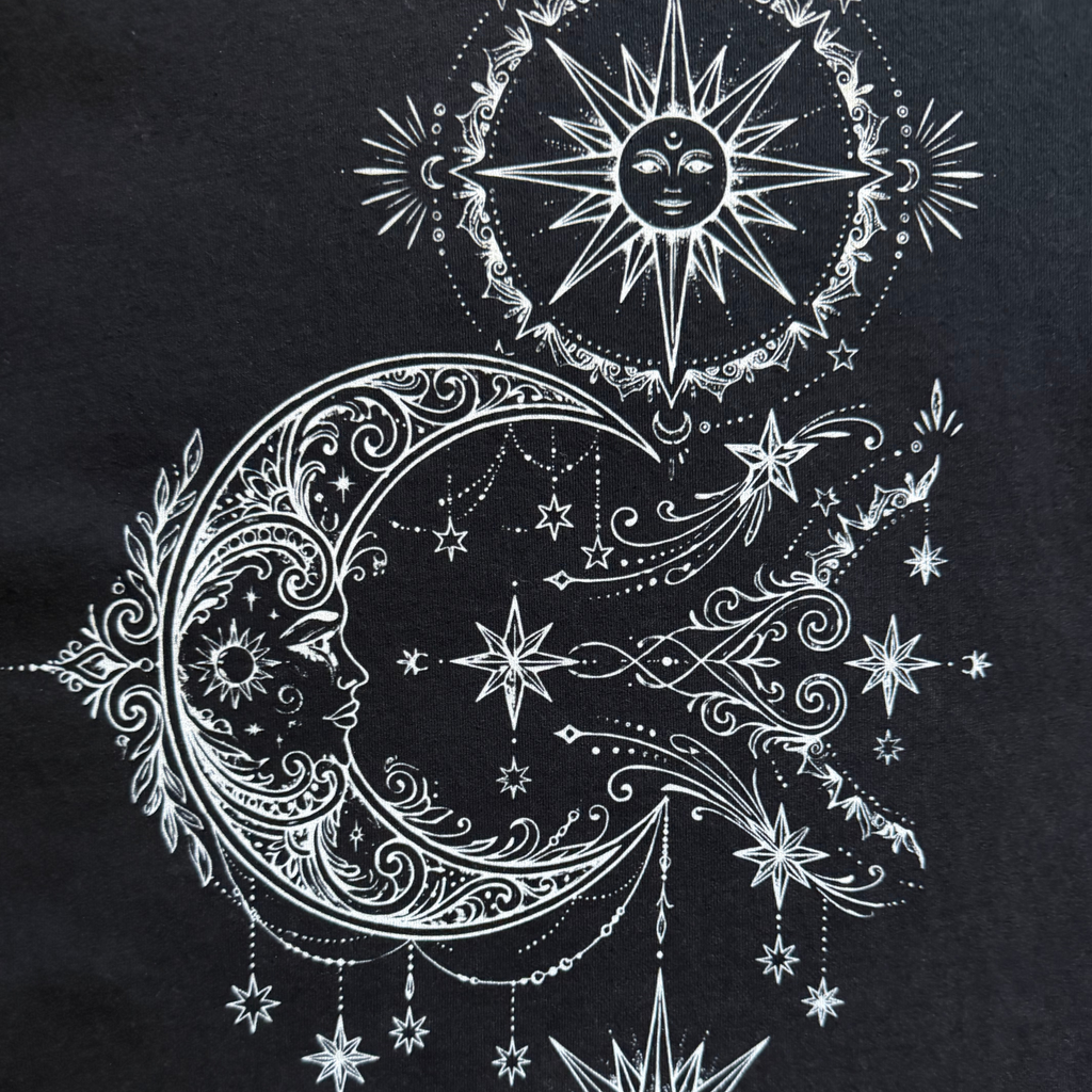 Decorative design of a moon, sun, and stars on a black background