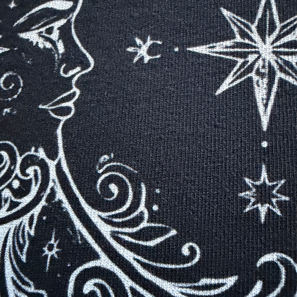 Black fabric with white celestial design featuring stars and moon.