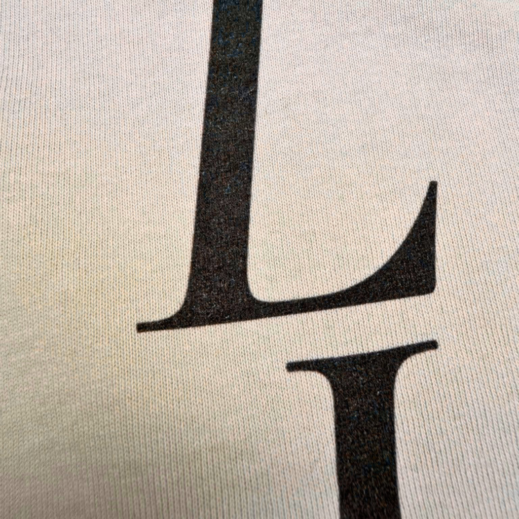 Close-up of a black 'L' on a textured beige background