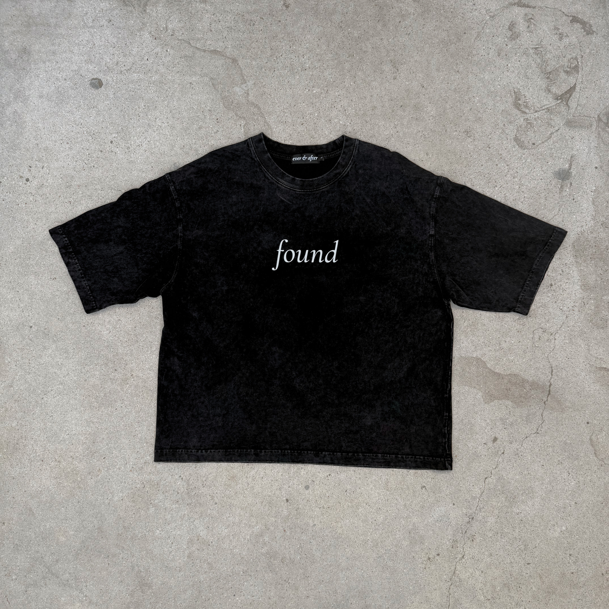 Black t-shirt with 'found' text on a concrete floor