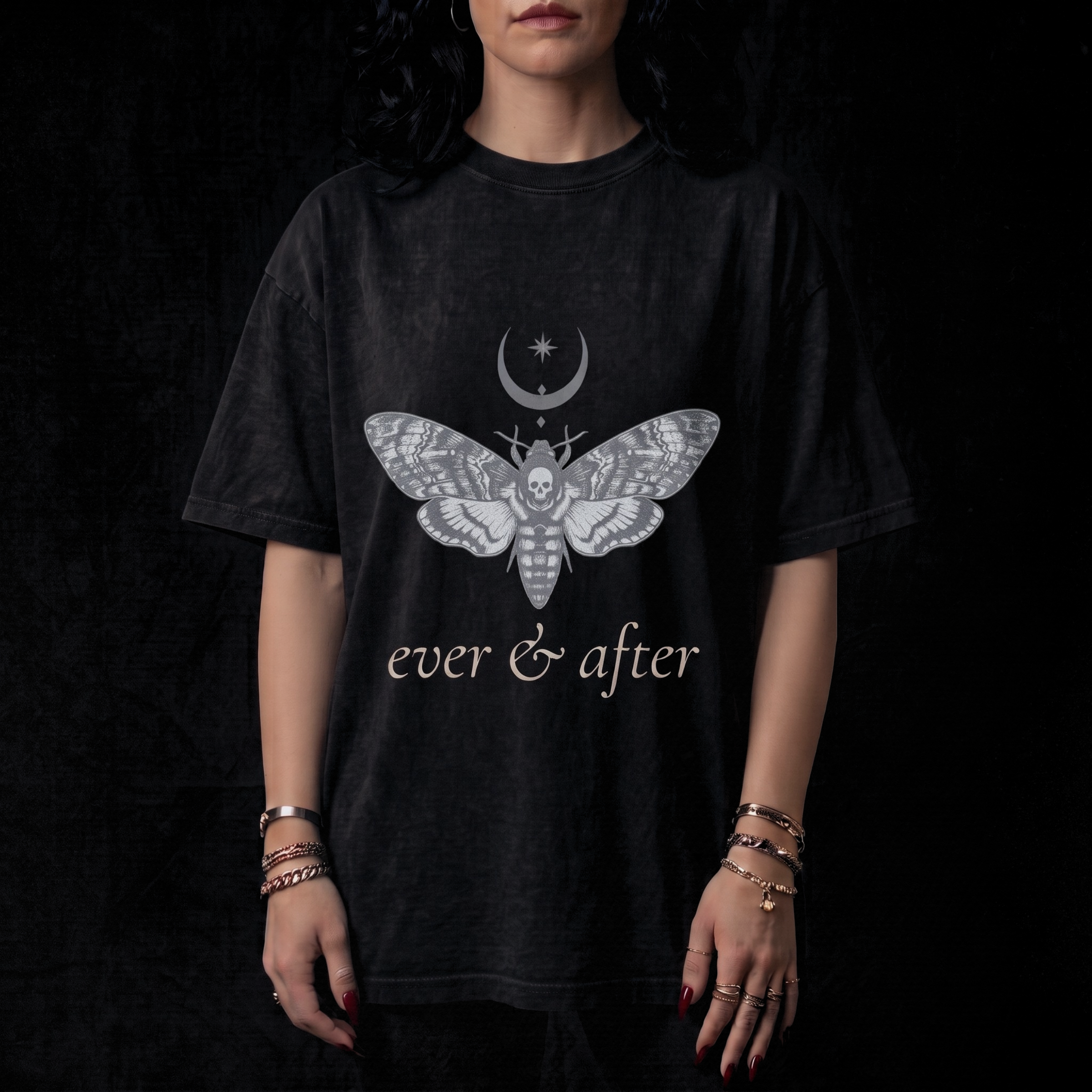 Person wearing a black t-shirt with a moth design and 'ever & after' text on a dark background