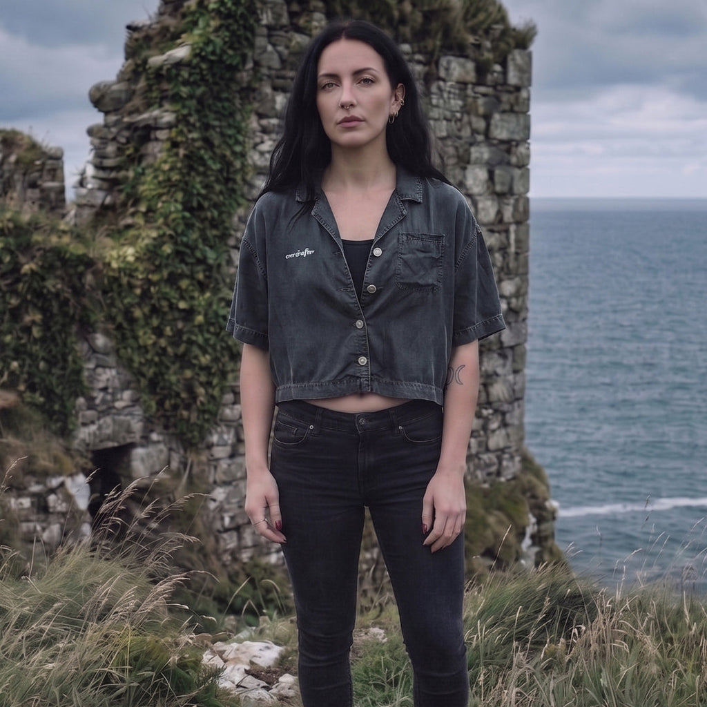 Woman standing in front of stone ruins with ocean view